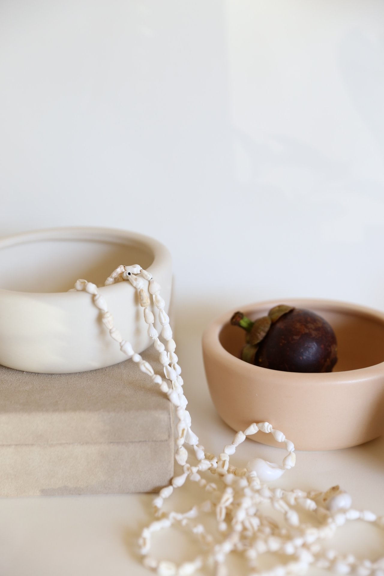 white and taupe round ceramic bowl vase