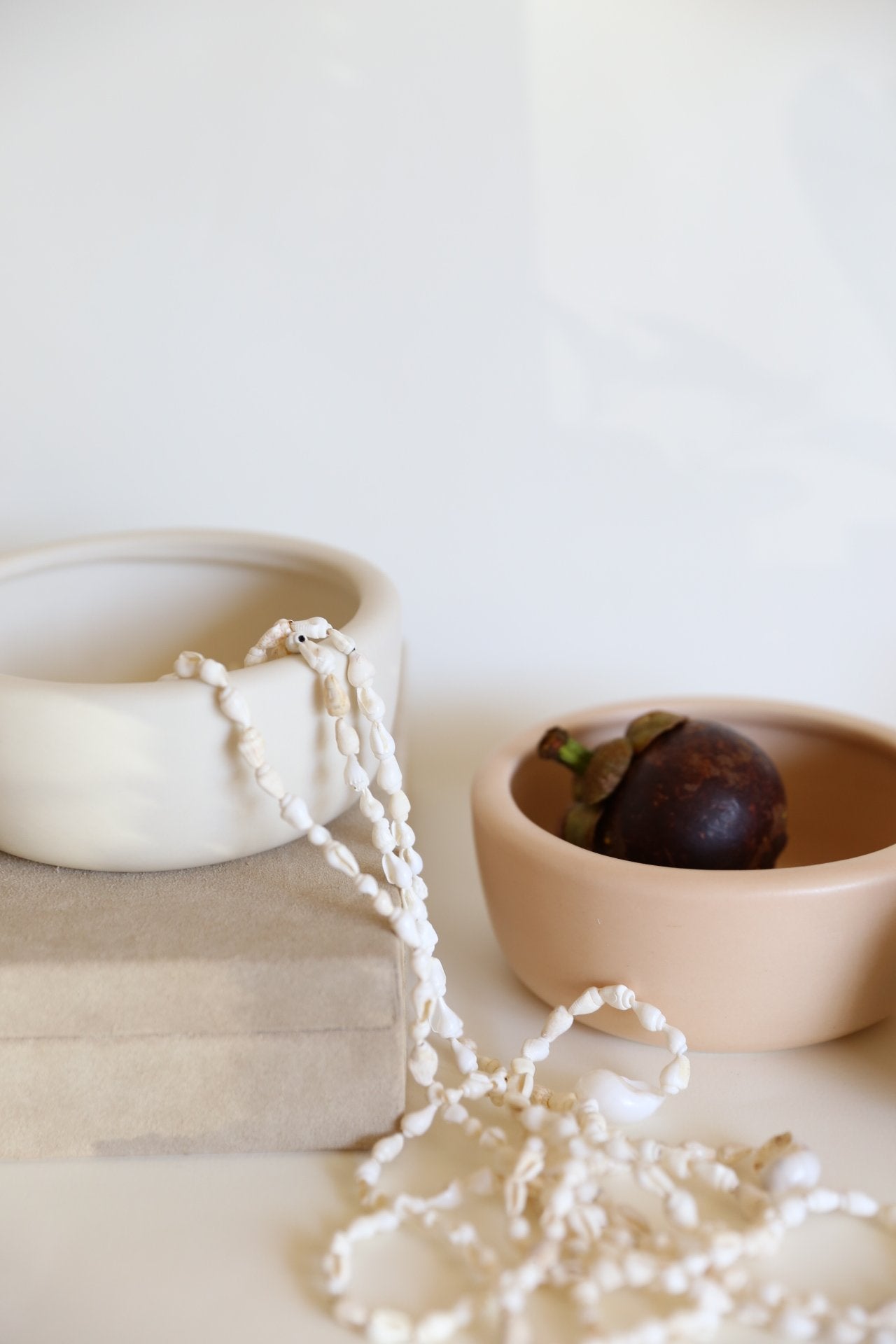 white and beige round bowls with shell garland